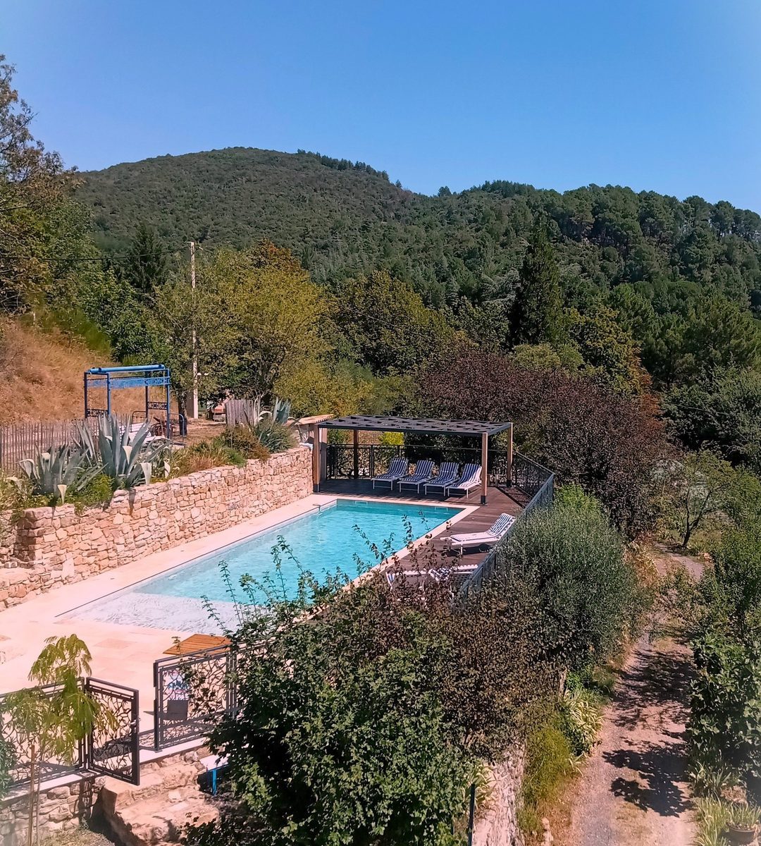 Vue aérienne de la piscine 13 × 4,5 m et de sa pergola, au-dessus du vallon cévenol